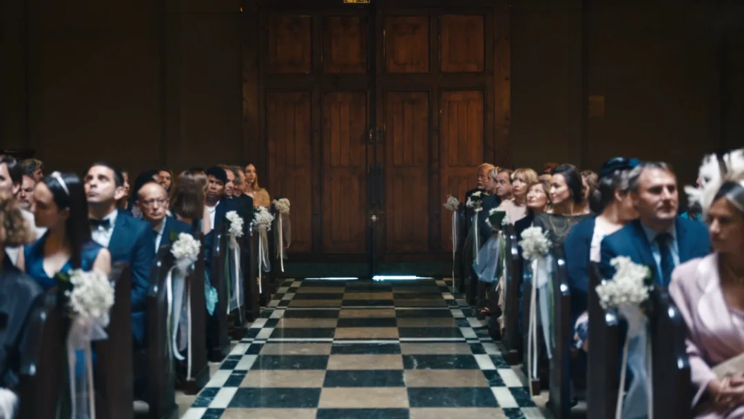 Chut : les invités d'un mariage assis de part et d'autre de l'allée d'une salle de cérémonie.